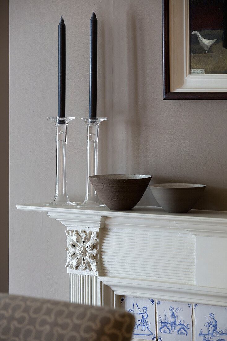 Ceramic bowls and glass candlesticks on mantlepiece in Victorian terraced house London England UK