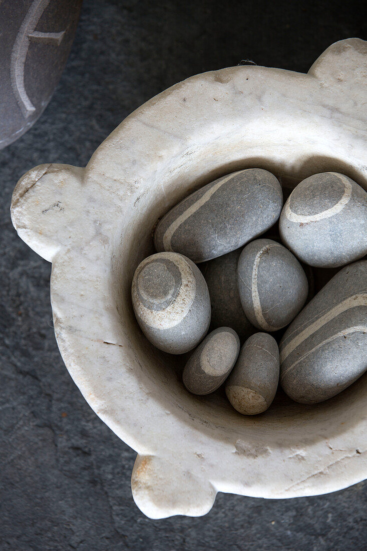 Sammlung von Kieselsteinen in einer Schale in einem Strandhaus in Sussex, England UK