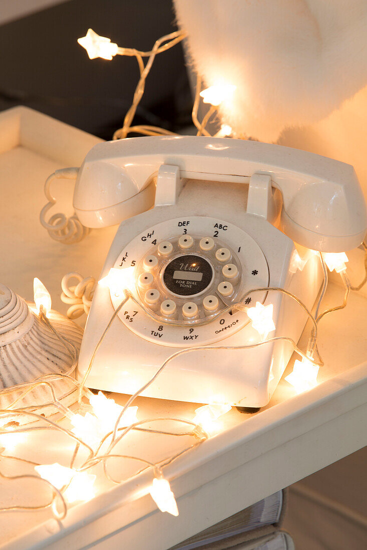 Rotary dial telephone with lit fairylights in South London family home England UK