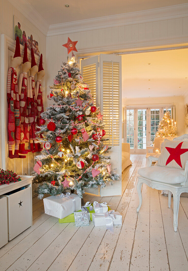 Weihnachtsgeschenke unter dem Baum mit Clowns im Wohnzimmer einer Familie in South London England UK
