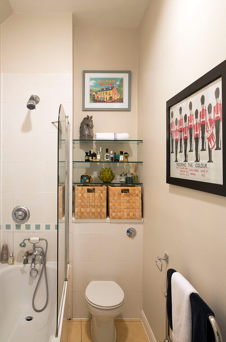 Glasregale und Kunstwerke in einem kleinen Badezimmer in einem Londoner Stadthaus UK