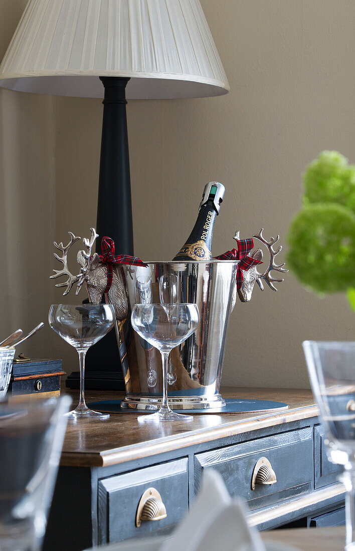 Icebucket and glasses with lamp on sideboard in London townhouse apartment UK