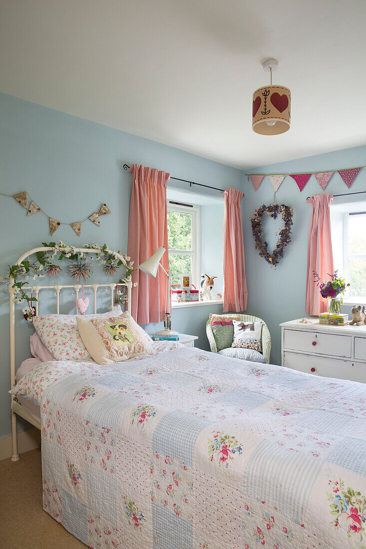Wimpel und Blumengirlanden im Mädchenzimmer in einem Cottage in Somerset, England, 19