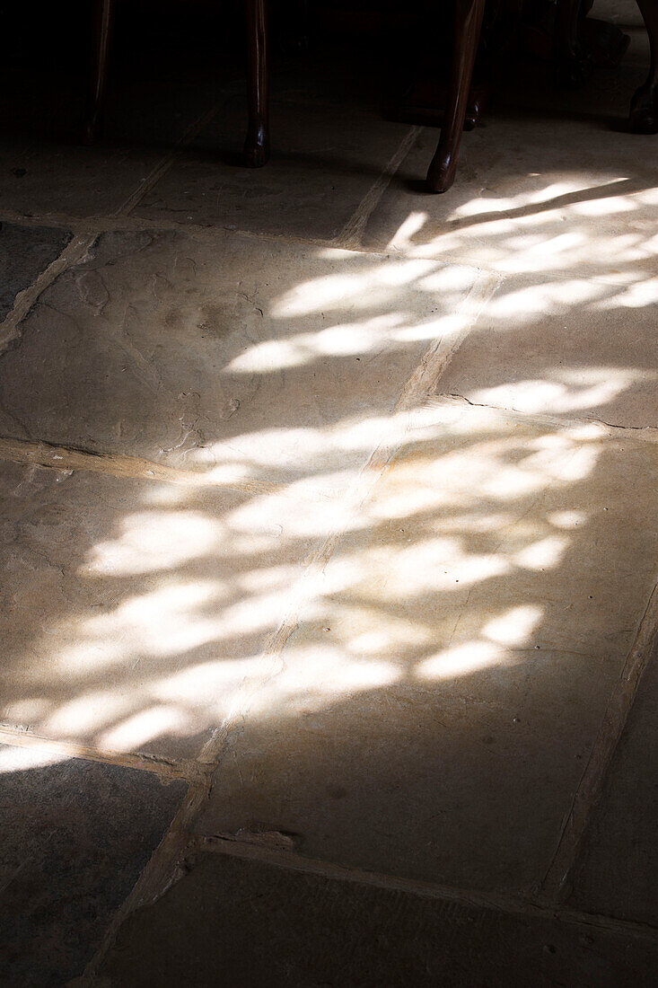 Geflecktes Sonnenlicht auf einer Steinplatte in einem historischen Bauernhaus in Kent UK