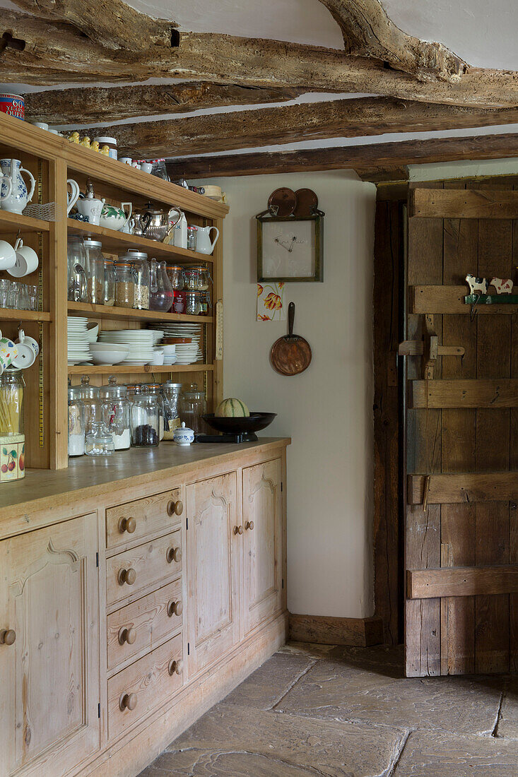 Geschirr und Gläser auf einer Kommode in einer Bauernhausküche mit Holzrahmen in Kent UK