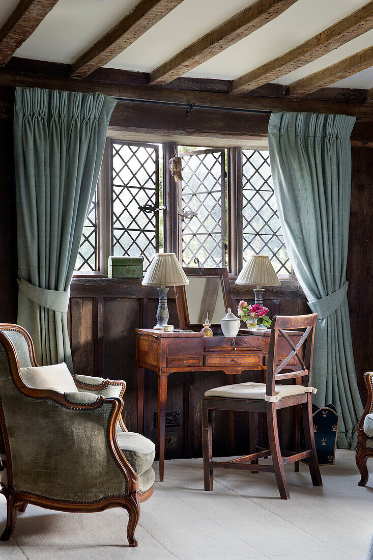 Frisiertisch und Stühle vor einem Bleiglasfenster in einem Bauernhaus mit Holzrahmen in Kent UK