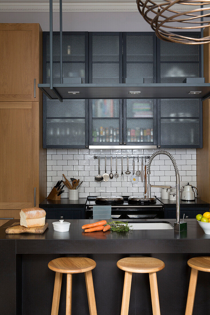 Holzhocker an der Frühstücksbar in einer modernen Küche in einem Londoner Stadthaus UK