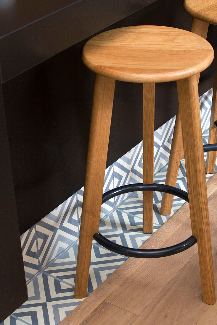 Wooden barstool on tiled and wooden floors in London townhouse UK