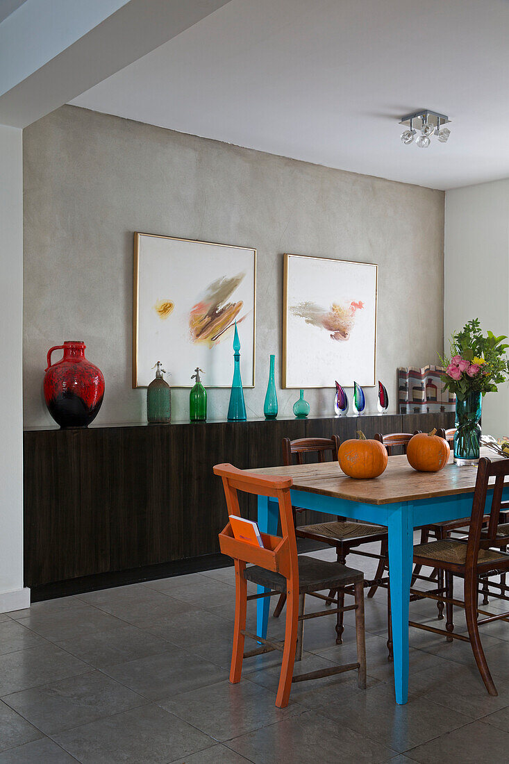 Esstisch und Stühle aus Holz mit moderner Kunst in einem Haus in London, England, UK