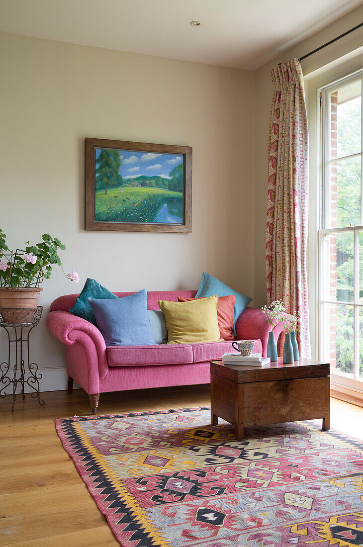 Two seater pink sofa and wooden coffee table with patterned rug in Grade II listed Georgian country house in Shropshire England UK