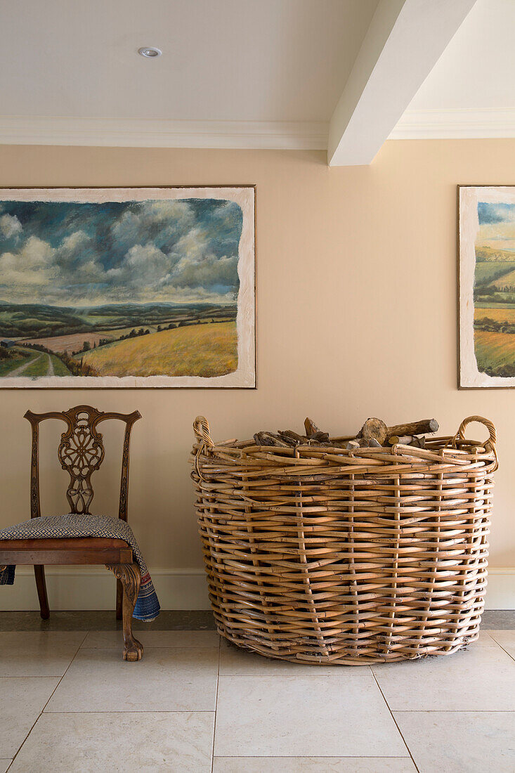 Oversized log basket ad chair with artworks in Grade II listed Georgian country house in Shropshire England UK