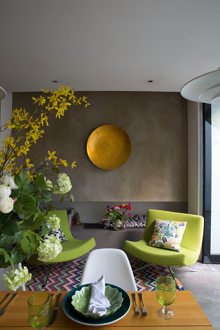 Schnittblumen auf einem gedeckten Tisch mit zwei lindgrünen Stühlen in einem modernen Londoner Stadthaus England UK