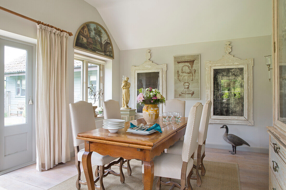 Esszimmerstühle am Holztisch mit Gänseornamenten und Kunstwerken in einem Bauernhaus in Dorset aus dem 18