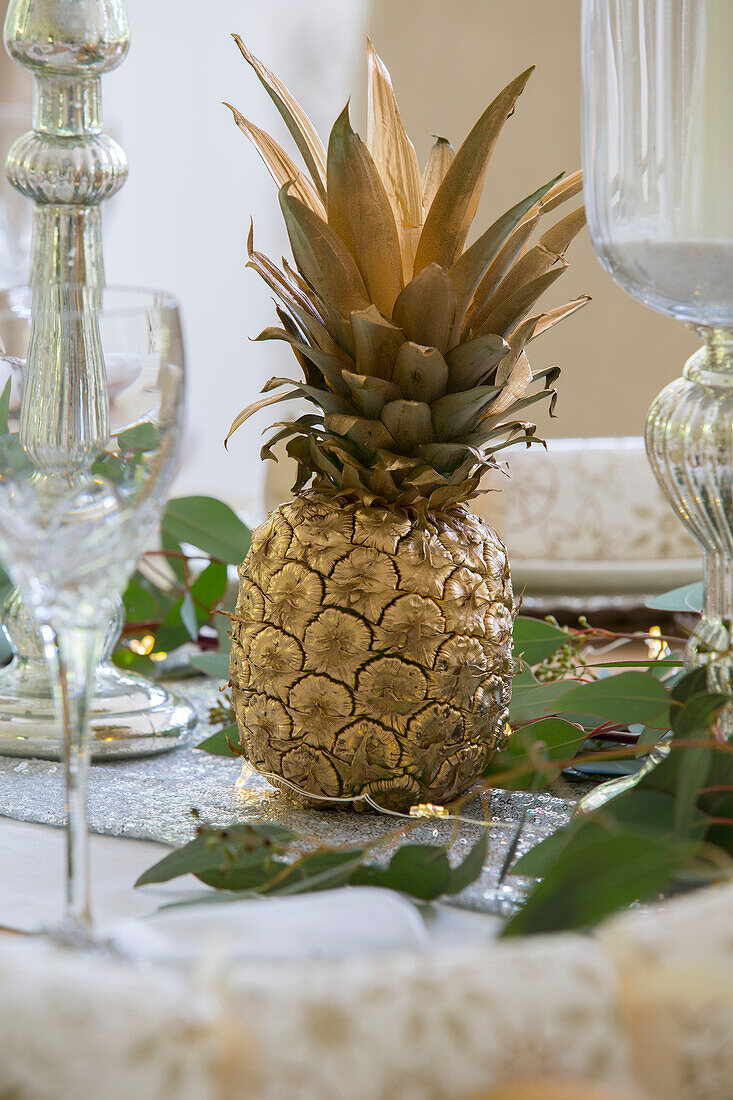 Goldene Ananas mit silbernem Kerzenständer auf Esstisch in Kent England UK