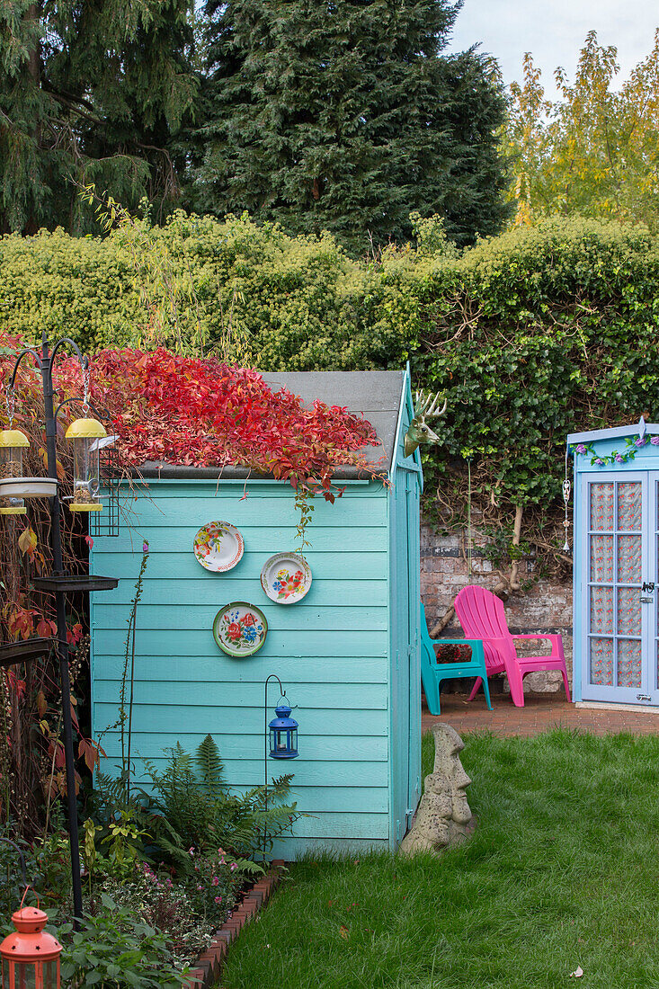 Türkisfarbener Schuppen und Gartenhaus mit Vogelfutterhaus in Kidderminster Garten Worcestershire England UK