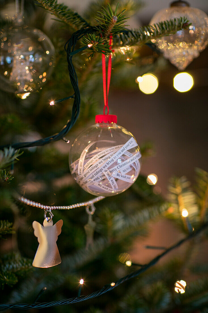 Christbaumkugel mit Liedzeilen am Weihnachtsbaum in einem Haus in Cheshire, Großbritannien