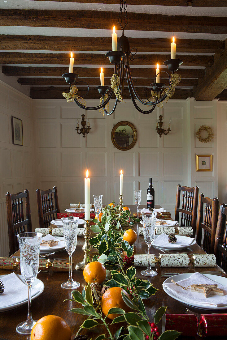 Candlelit dining table at Christmas in timber-framed Hampshire farmhouse England UK