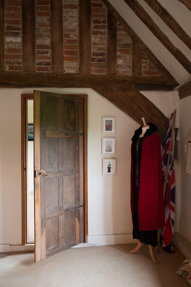 Cloak on mannequin in timber-framed room of Hampshire farmhouse England UK