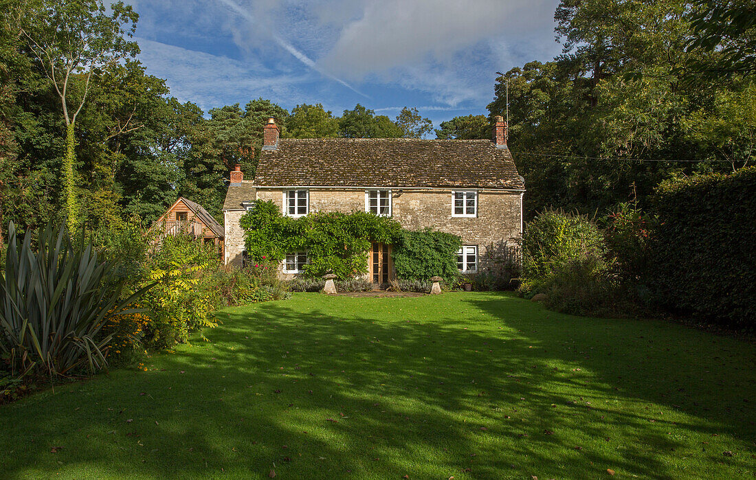 Schatten auf dem Rasen im Garten eines freistehenden Cottages in Gloucestershire UK