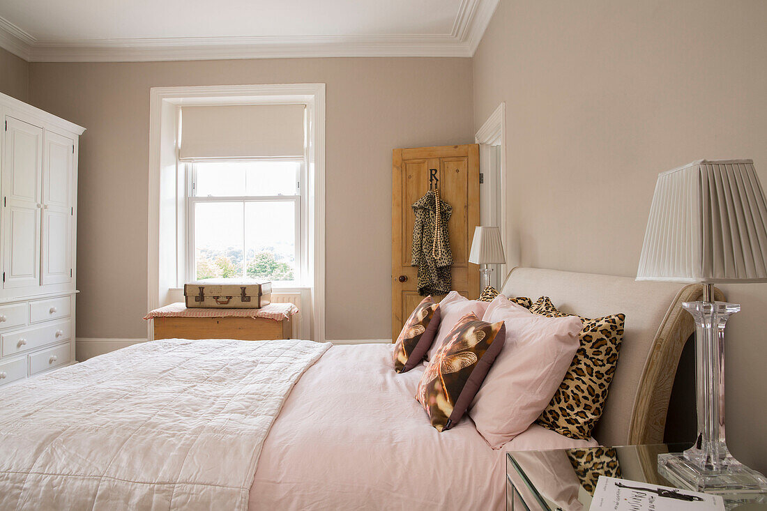 Hellrosa Doppelbett mit Kissen und Mantel mit Tiermotiven in einem Haus in Brighouse, West Yorkshire, Großbritannien