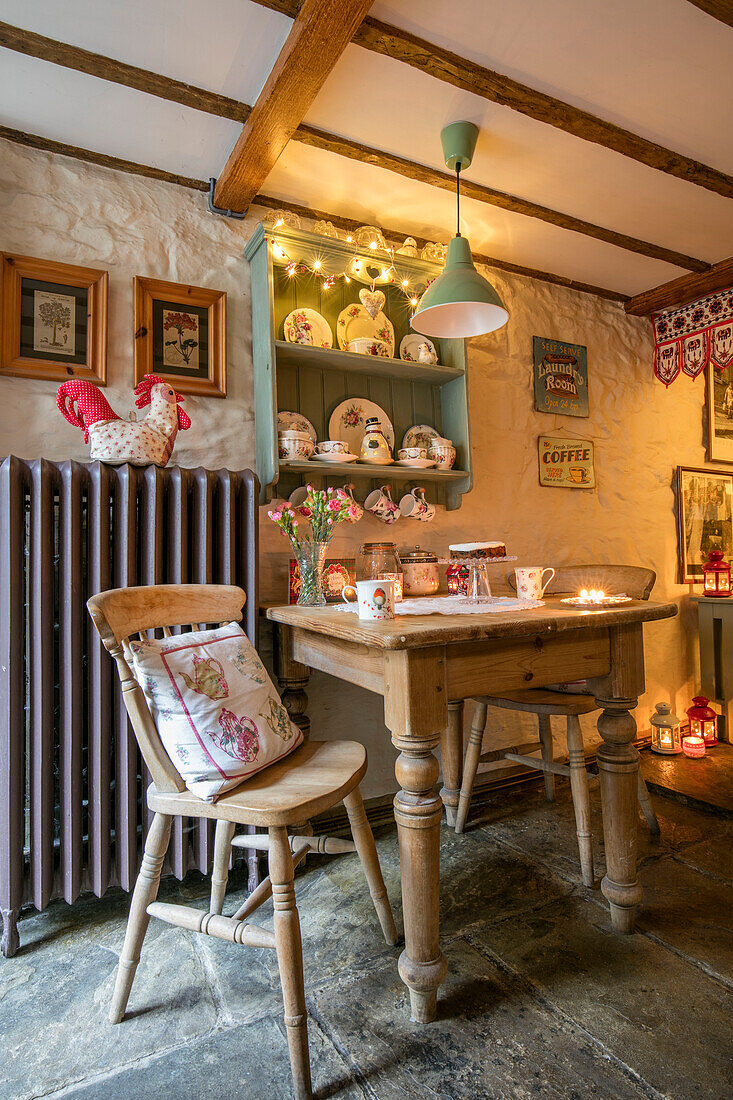 Wooden table and chairs with large radiator and fairylights in Georgian cottage Liverpool UK