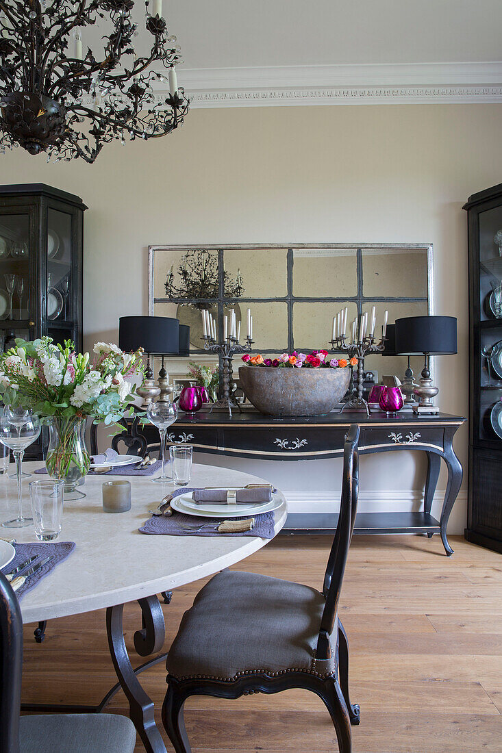 Esszimmerstuhl am gedeckten Tisch mit Konsole und Spiegel in einem freistehenden Landhaus in Sussex UK
