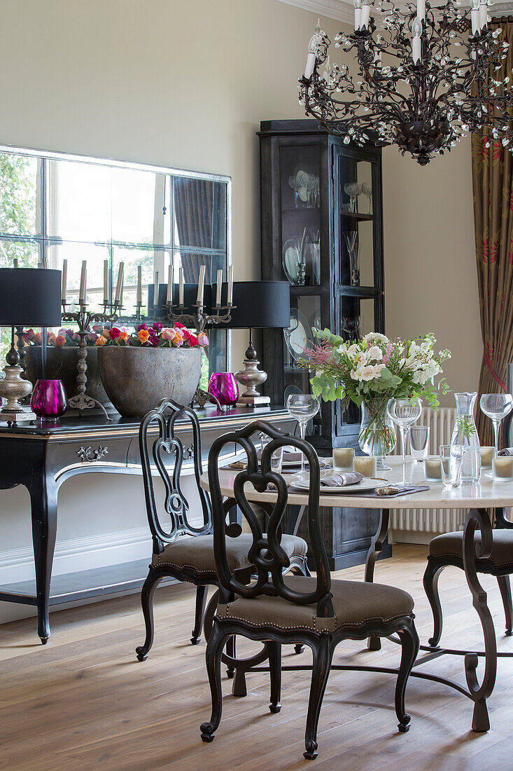 Esstisch und Stühle mit Konsole und Spiegel in einem freistehenden Landhaus in Sussex UK