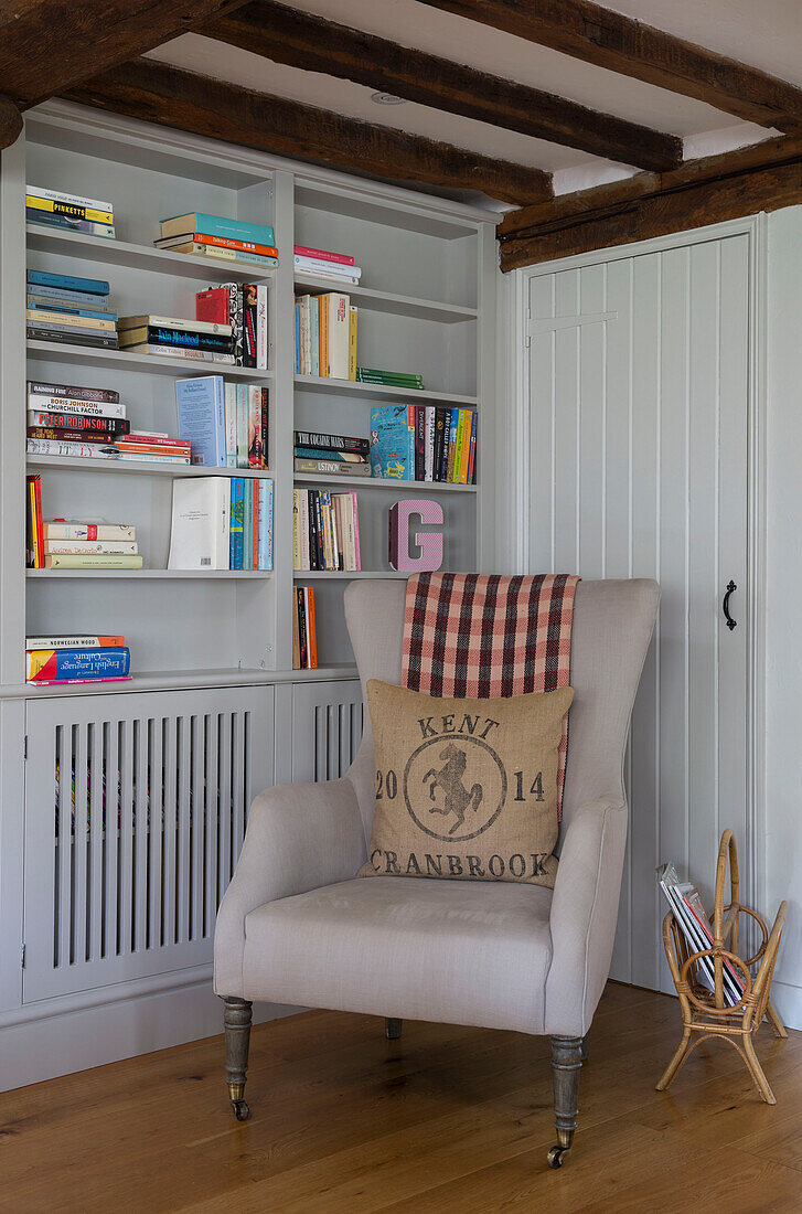 Sessel und Bücherregal mit Zeitschriftenständer in Oast house conversion, Kent, England