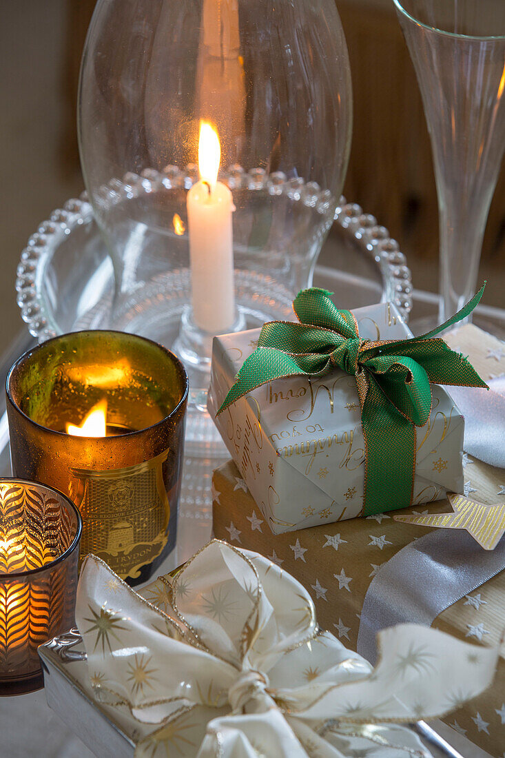 Beleuchtete Teelichter mit Weihnachtsgeschenken in einem Londoner Stadthaus UK
