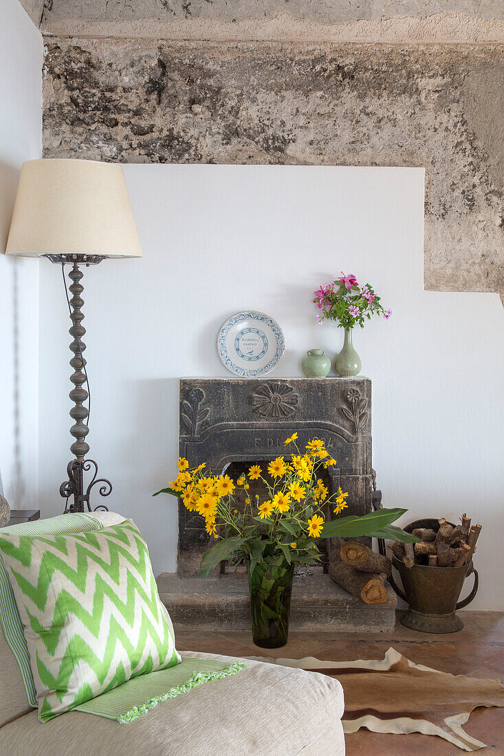 Yellow flowers in fireplace with lamp and cushion in coastal villa Amalfi Italy