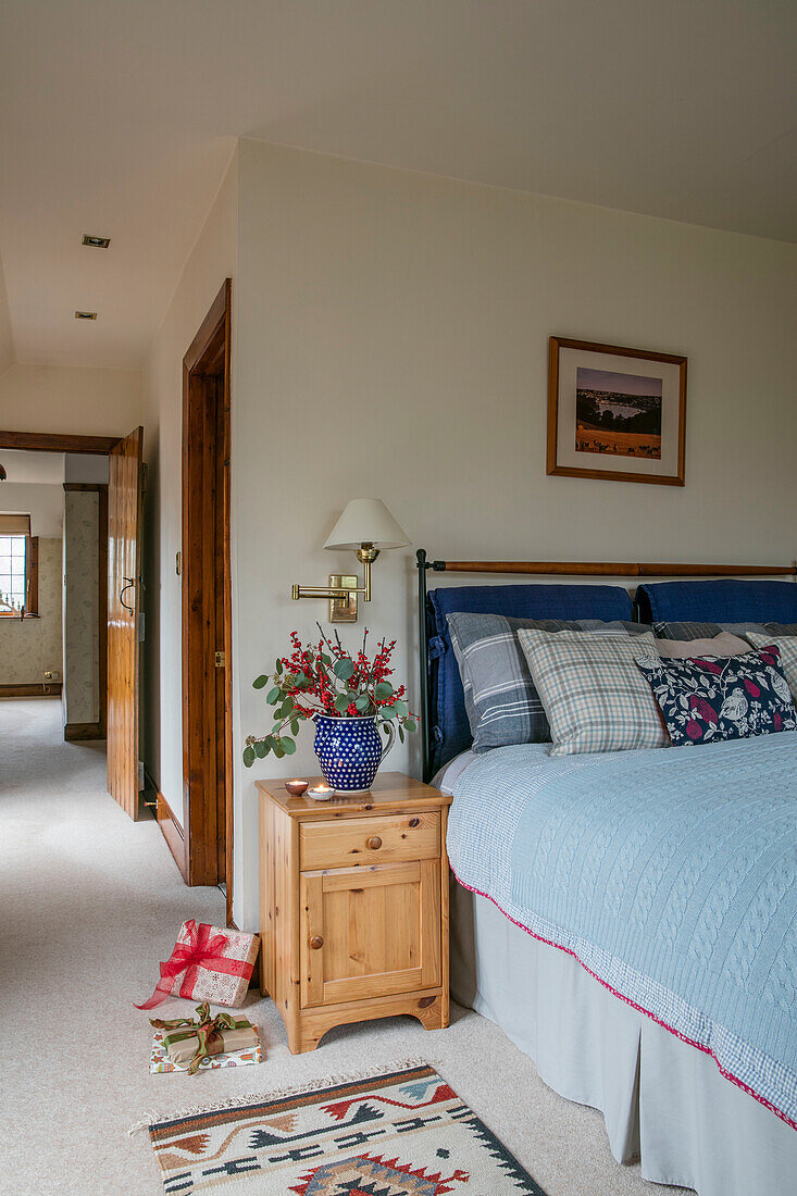 Hellblauer Bezug auf einem Doppelbett mit Holzschrank in einem Haus in Berkshire UK