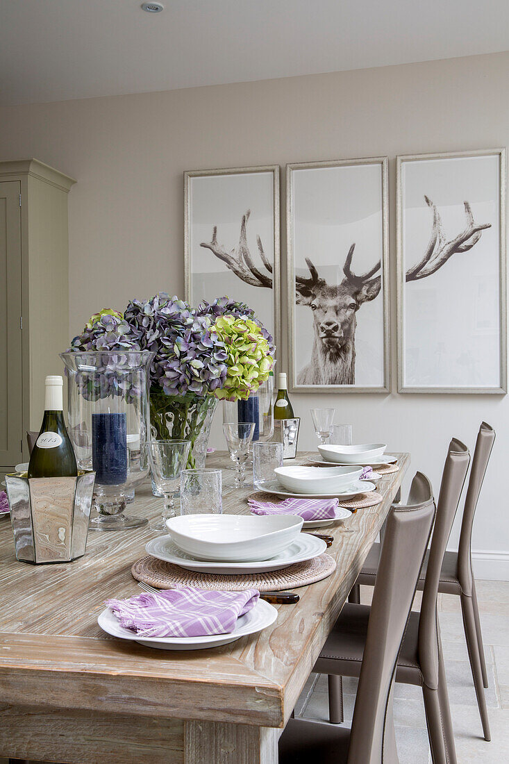 Triptych of deers head with hydrangea on dining table in London townhouse UK