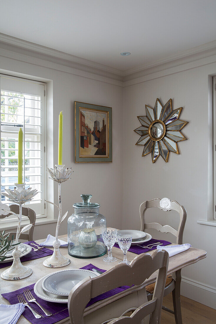 Sunburst mirror with candles on dining table in West Sussex home