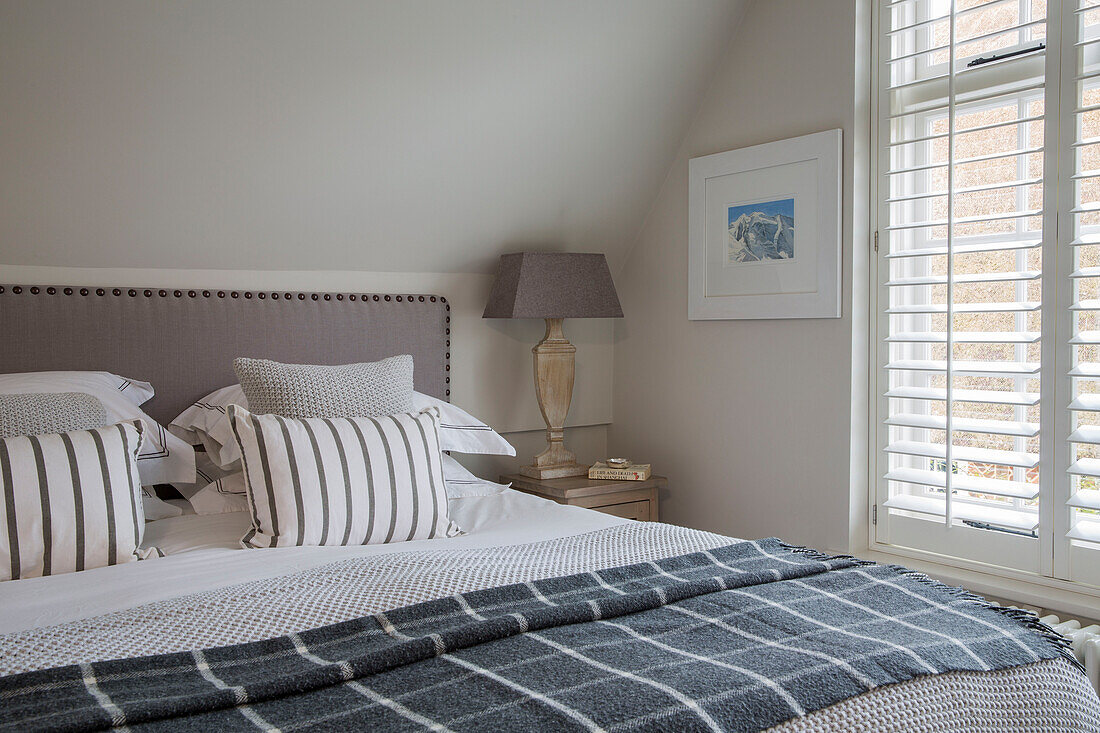 Dark grey blanket on double bed in West Sussex home