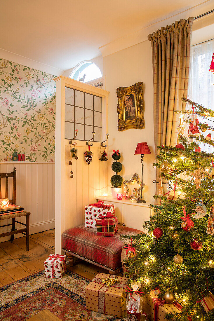 Weihnachtsgeschenke unter dem Baum hinter der Trennwand am Eingang eines Hauses in Liverpool (UK)