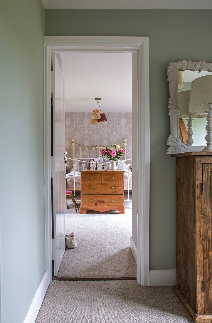 Kommode im Schlafzimmer mit Blick durch den Türrahmen in einem Einfamilienhaus aus den 1950er Jahren in Alford, Surrey, Großbritannien