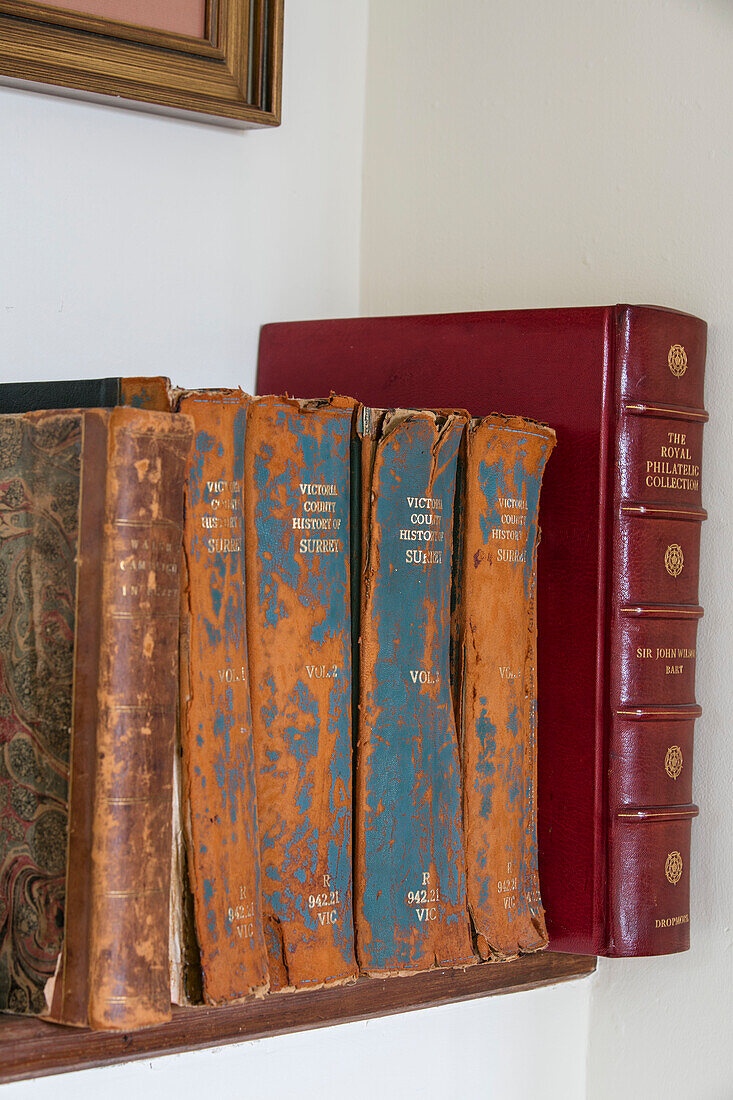 Ageing hard-backed books on shelf in West Sussex townhouse UK