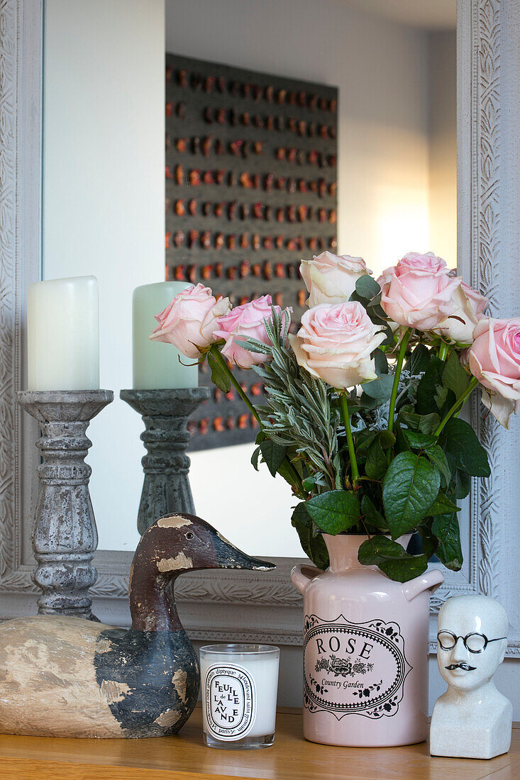 Rosa Rosen und Ente mit Kerzenständer im Spiegel eines Londoner Hauses UK
