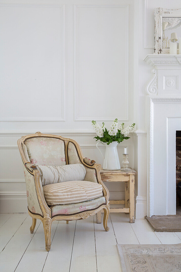 Cream armchair and side table with cut flowers in Edwardian house Surrey UK