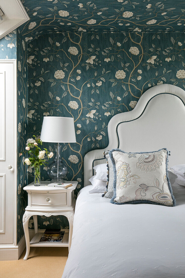 Teal and white floral wallpaper in bedroom of Wiltshire home England UK