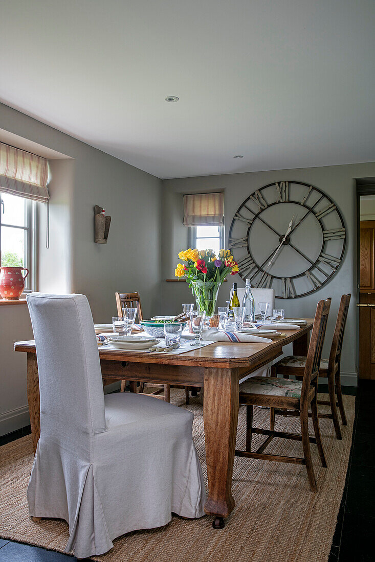 Large clock in light grey dining room with coir mat in Somerset farmhouse UK