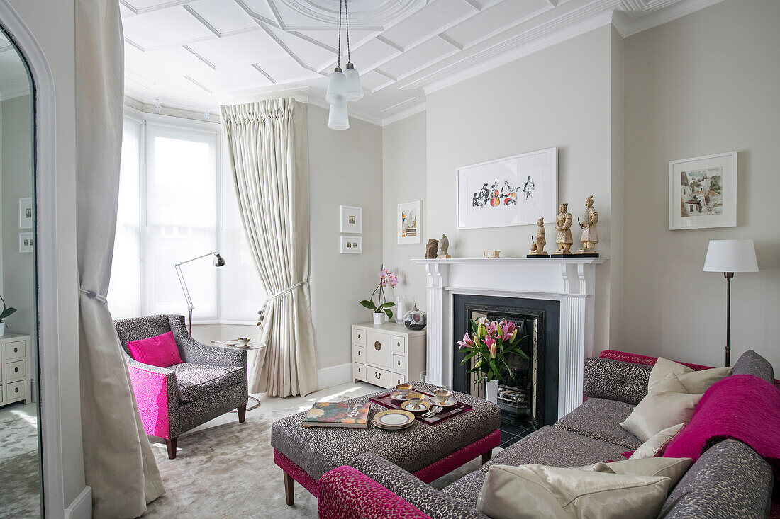 Graue und rosafarbene Polstermöbel im Wohnzimmer einer viktorianischen Terrasse in London UK