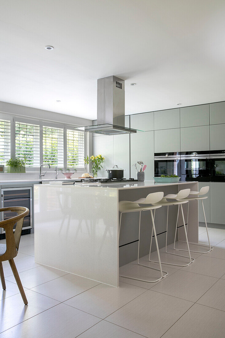 Geräumige moderne Küche mit Barhockern und Holzstühlen in Surrey home UK