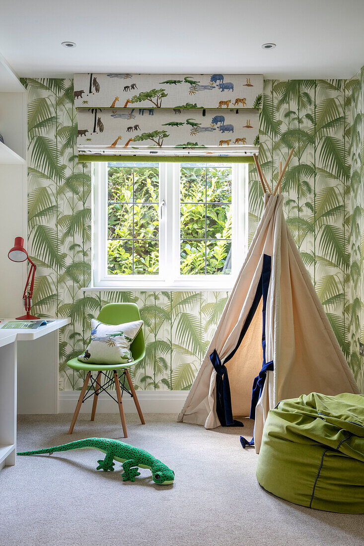 Palm leaf patterned wallpaper and wigwam in playroom of Surrey home UK