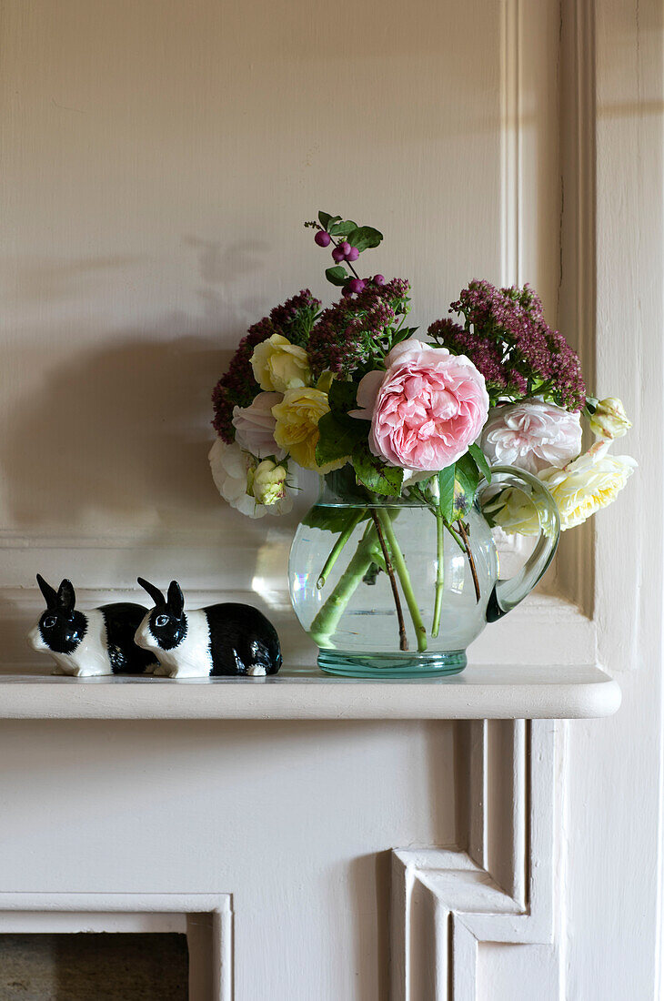 Cut flowers with china rabbits on mantlepiece in Somerset home UK
