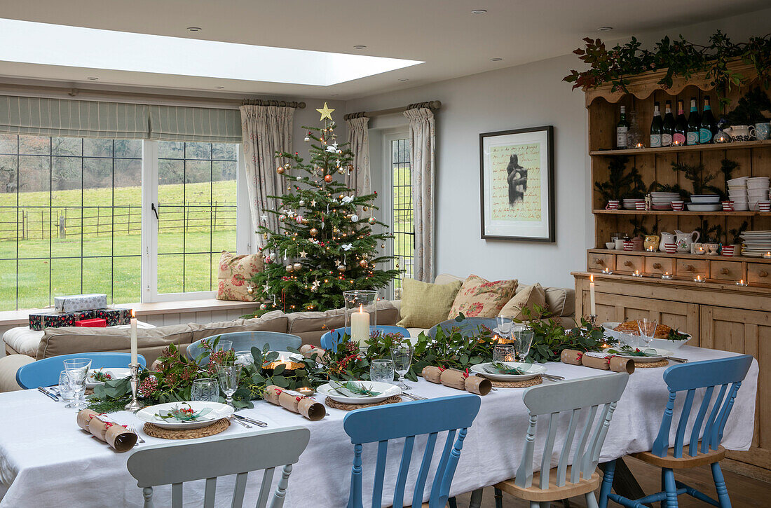 Blauer und weißer Esstisch mit Weihnachtsbaum in einem Haus aus den 1930er Jahren im Stil des Arts and Crafts in West Sussex, Großbritannien