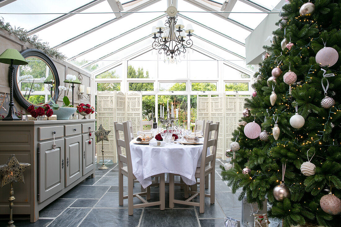 Christmas tree in conservatory with dining table and sideboard in Hampshire home