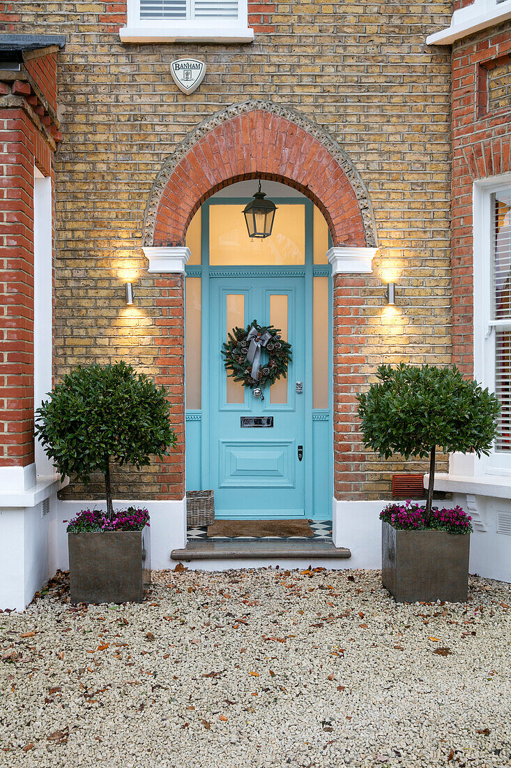 Clipped trees at brick entrance painted Blue Ground - Edwardian house in East Dulwich London UK