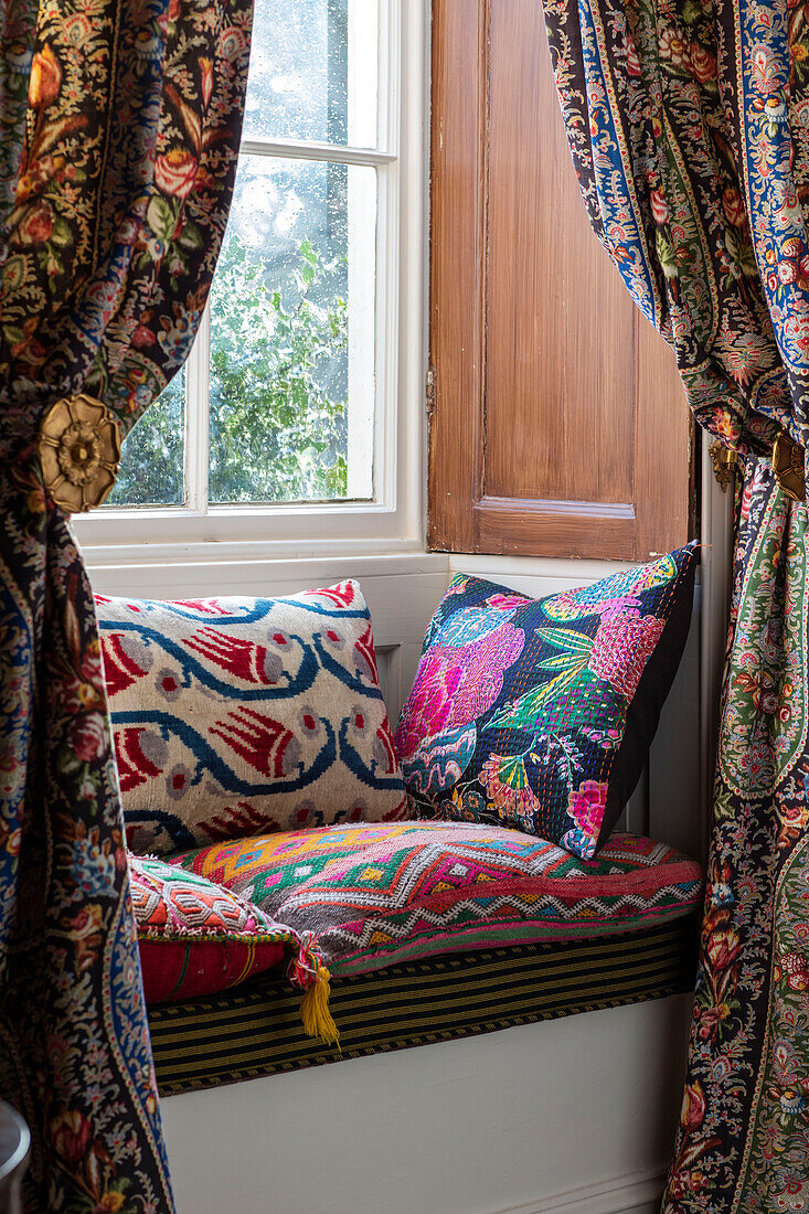 Windowseat with mixed textiles and patterns in Georgian home Hertfordshire England UK