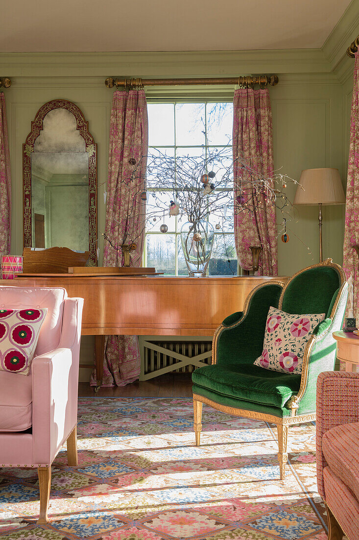 Musikzimmer mit rosa geblümten Vorhängen und grünem Samtsessel in einem georgianischen Haus in Hertfordshire, England, UK